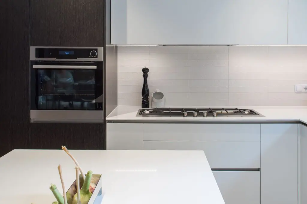 Moderní černobílá kuchyně s ostrůvkem a keramickou pracovní deskou