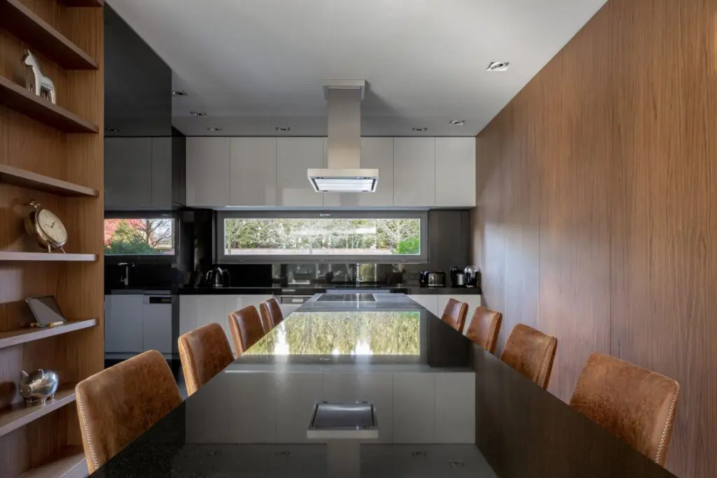 Luxusní černo bílá kuchyně do U se dřevem a kamennou pracovní deskou